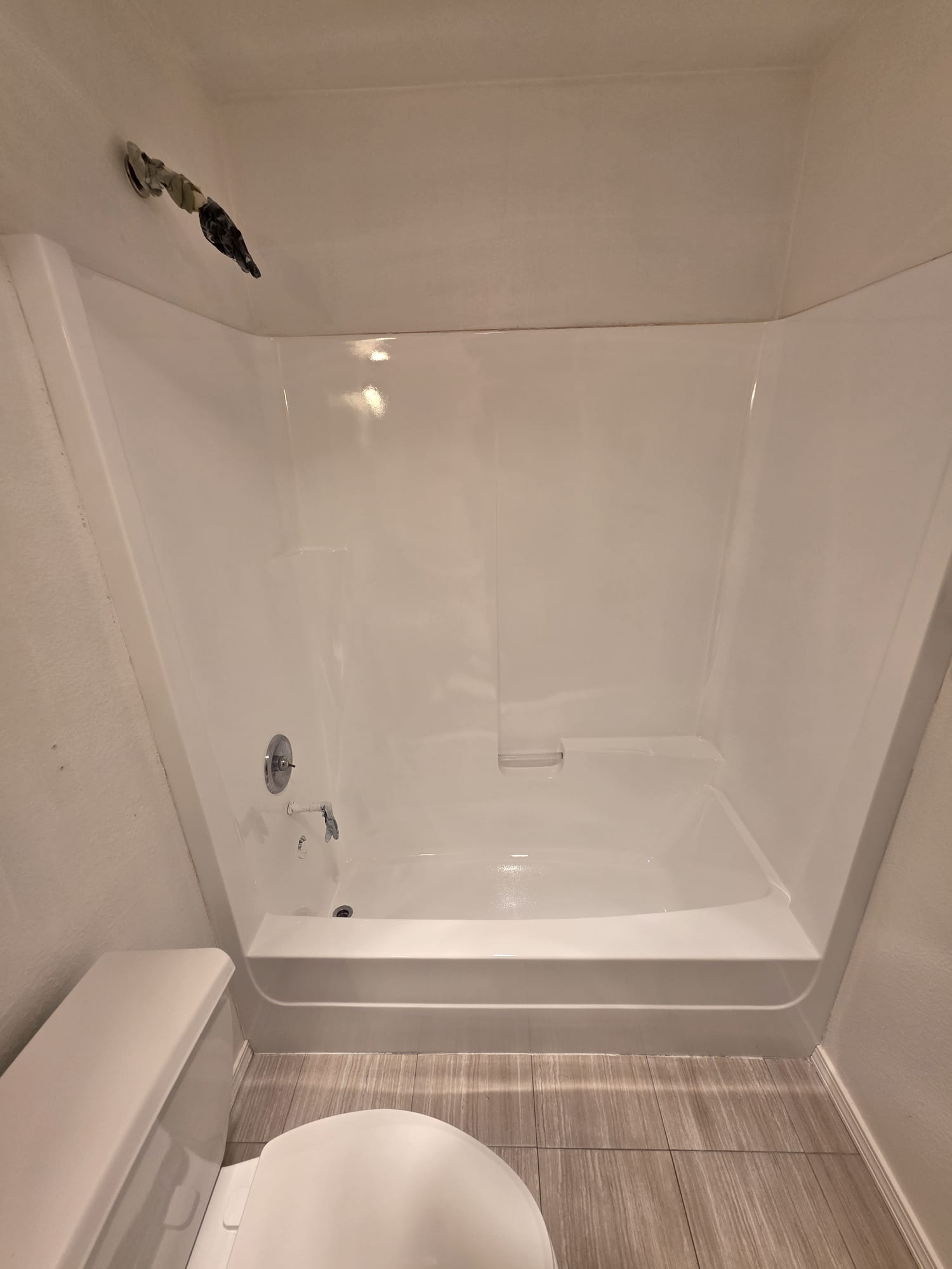 Freshly resurfaced white bathtub and surround with a clean, glossy finish